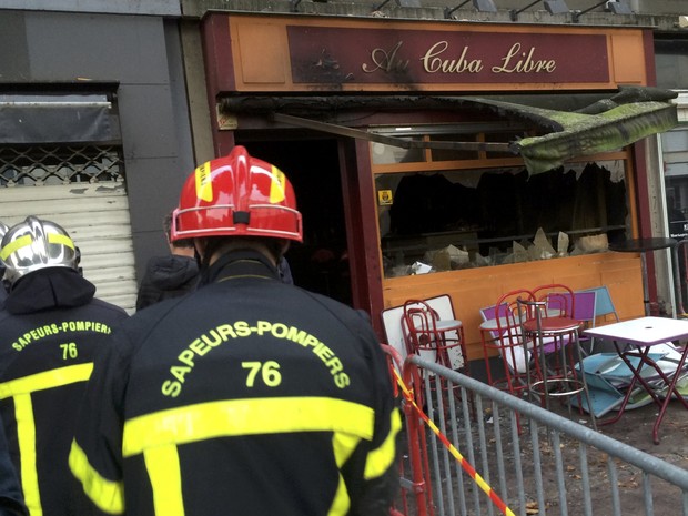 Bombeiros em frente ao bar Au Cuba Libre, onde 13 pessoas morreram e seis ficaram feridas após incêndio (Foto: Clotaire Achi/Reuters)