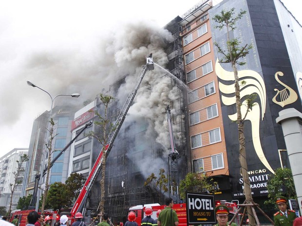 Bombeiros tentam controlar fogo em prédio em Hanói (Foto: STR / AFP)