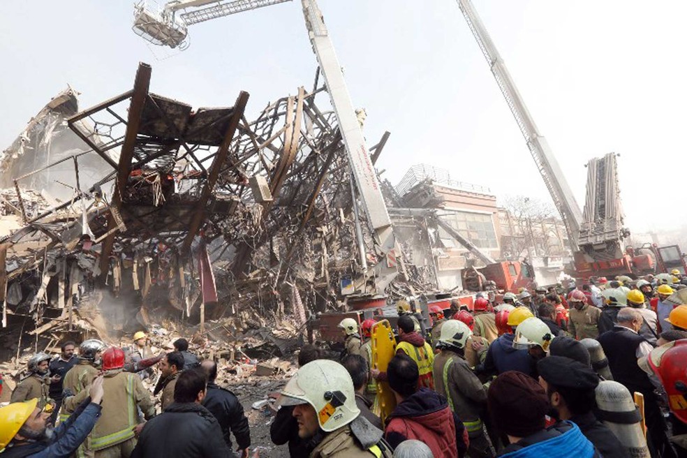 Bombeiros fazem buscas para localizar vítimas de desabamento de prédio em Teerã (Foto: STR / AFP)