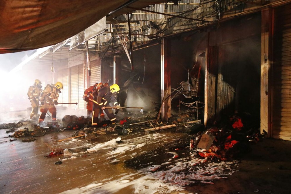 Bombeiros com material em mãos para combater incêndio na Feira dos Goianos (Foto: Corpo de Bombeiros/Divulgação)